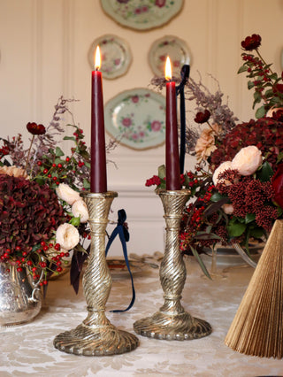 Pair of vintage pressed glass candlesticks with mercury glass effect on an elegant table