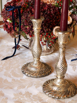 Close-up of vintage pressed-glass candlesticks with scalloped bases