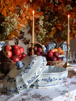 Hand-painted antique tureen displayed on a floral tablecloth