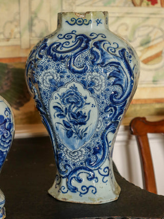 Blue and white Delft ceramic vases displayed on antique furniture