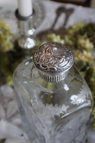 antique etched decanter with a silver lid