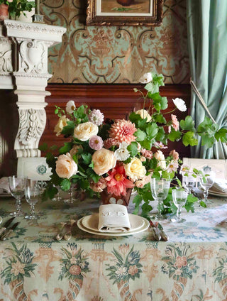 A table set with a sage green Zardi & Zardi botanical printed tablecloth, brass candelabra and crystal glassware — Maison Fête et Cie.