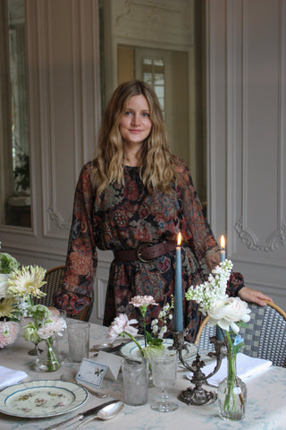 Founder Miranda Uechtritz standing in front of a dinner table setting in a paris apartment 