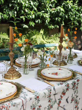 Pair of antique gilt bronze candlesticks styled on an outdoor table with antique floral china and garden flowers