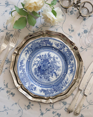 Stack of seven blue and white chinoiserie transferware plates showing depth of the set
