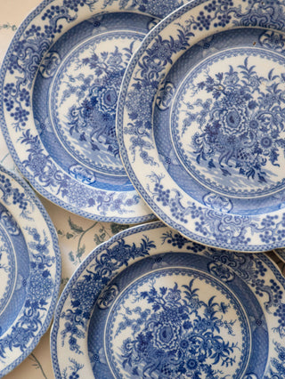 Chinoiserie transferware plates fanned out to show consistency of pattern across the set
